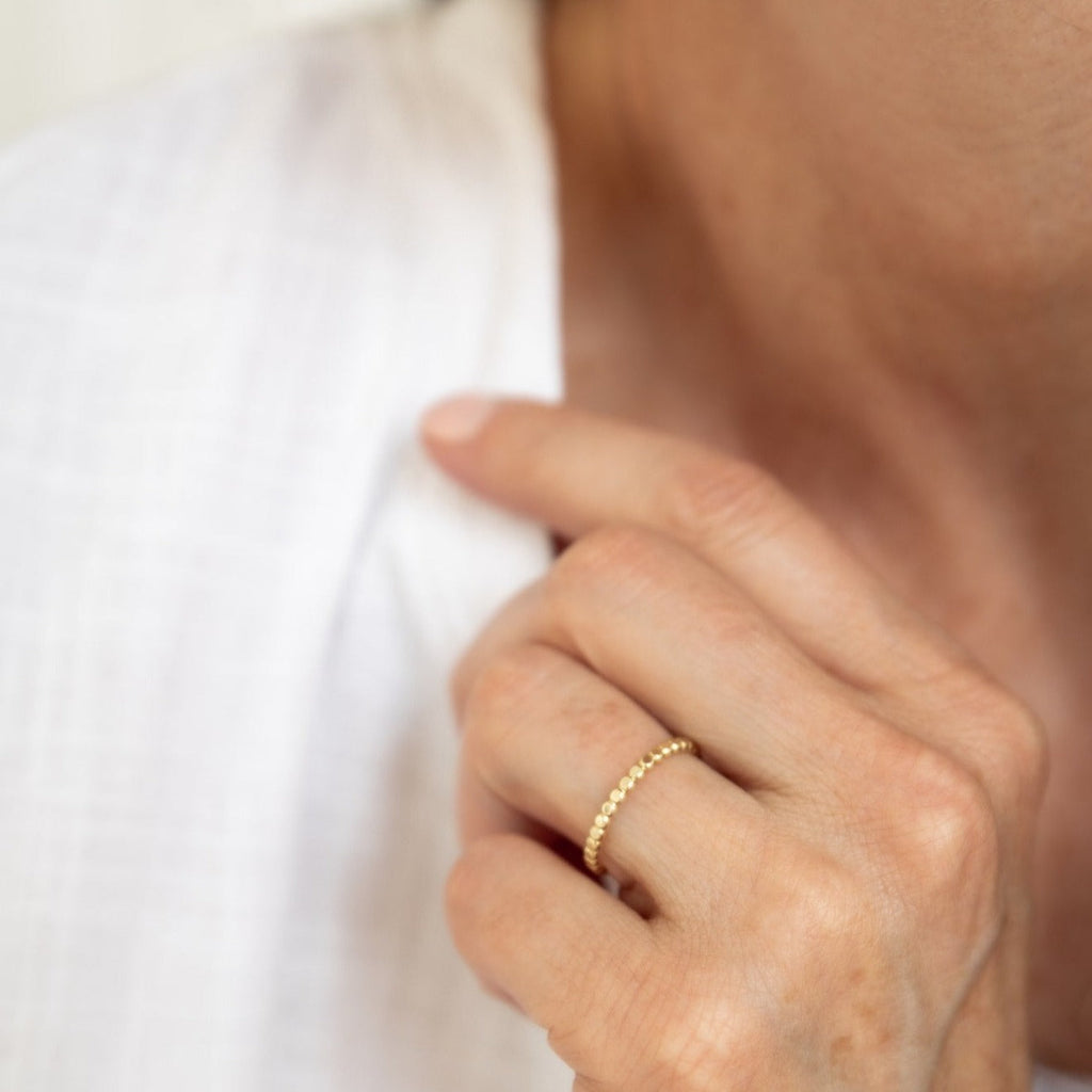 Woman wearing a solid 14k gold beaded ring