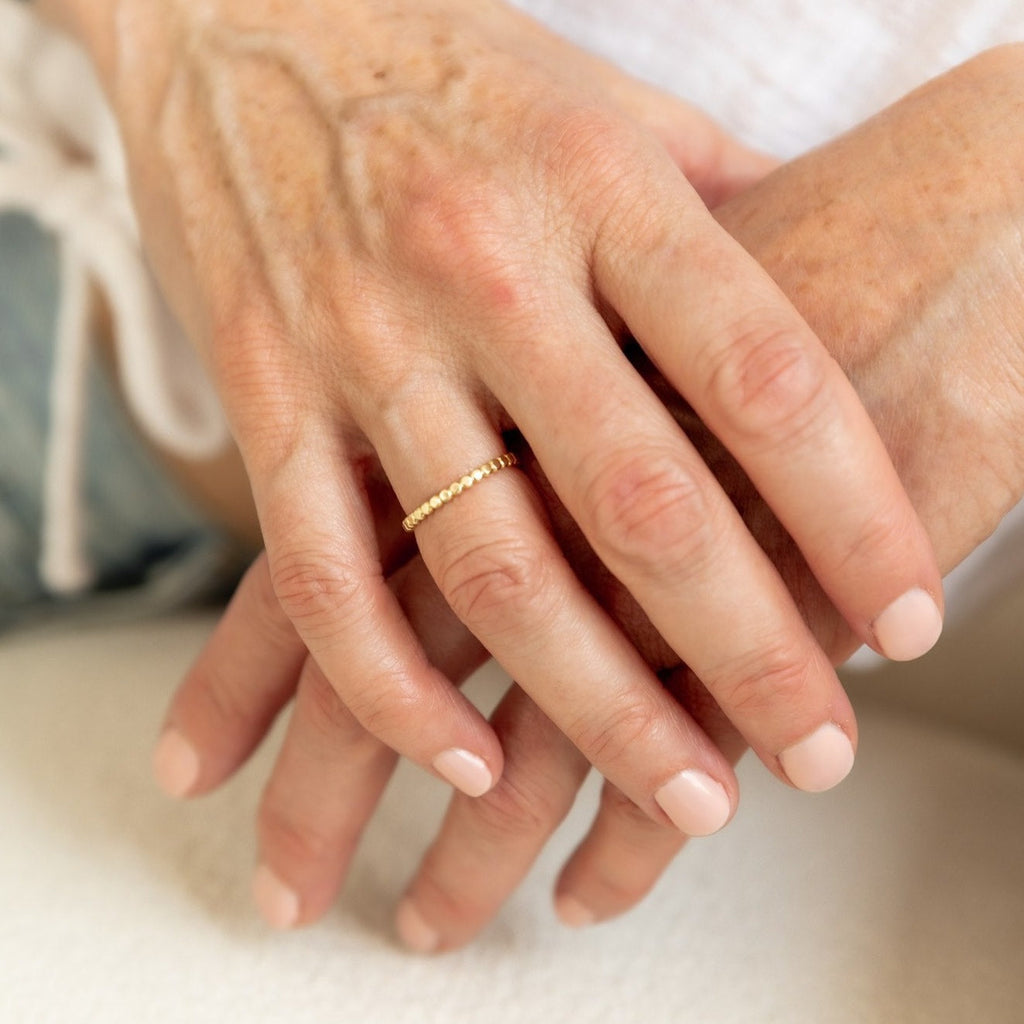 Woman wearing a solid 14k gold beaded ring