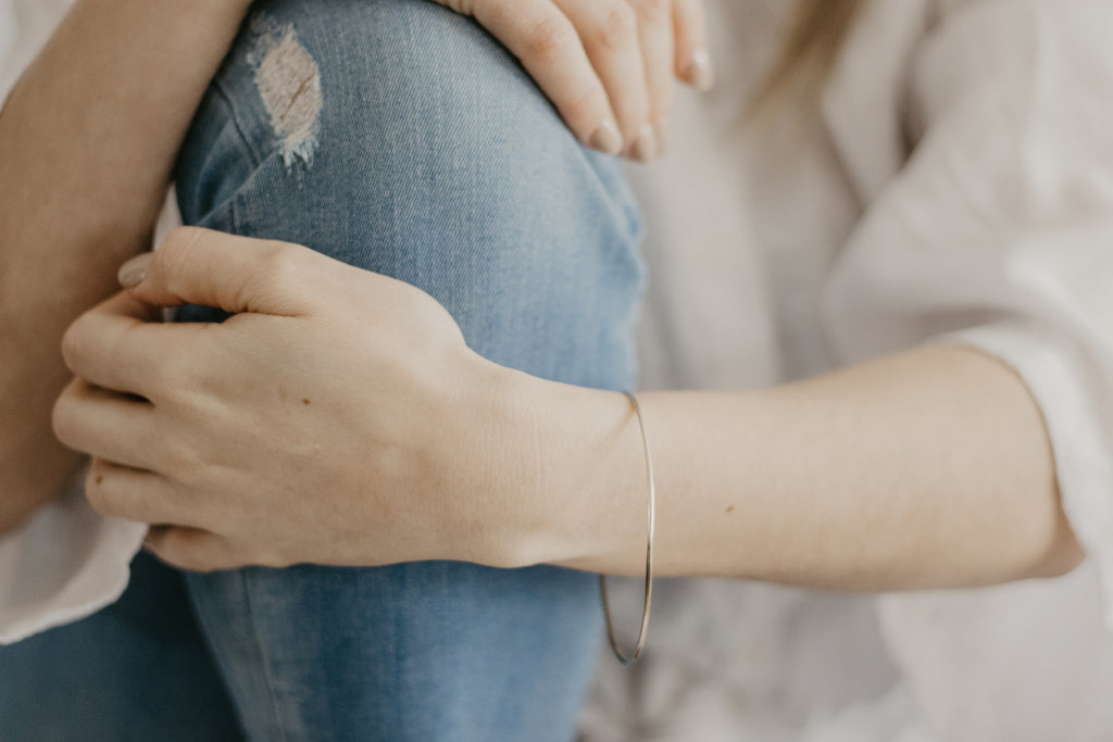 Woman wearing minimalist, handcrafted solid gold bangle