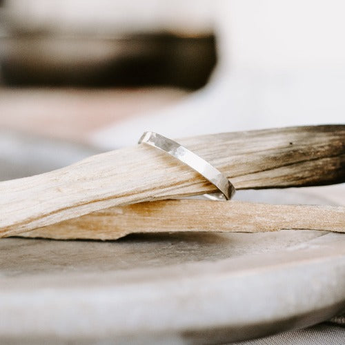 Sterling Silver 2.5mm hammered ring on a burnt piece of wood