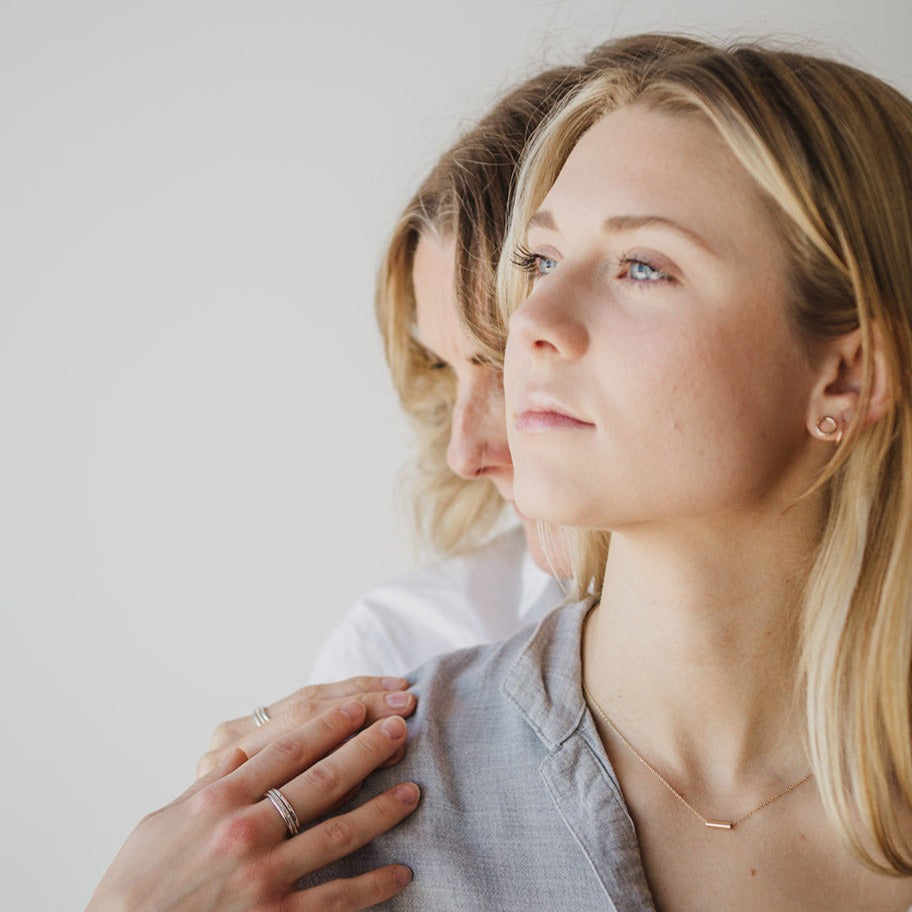 Mother standing behind daughter who is wearing a FRIEDA Jewelry 14k solid gold necklace