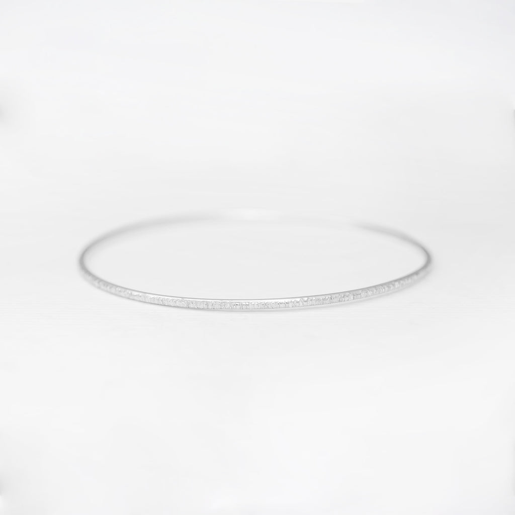 Minimalist handmade sterling silver stacking bangle in a birch texture